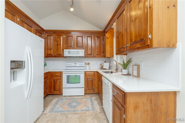 kitchen with vaulted ceiling, backsplash, sink, and white appliances