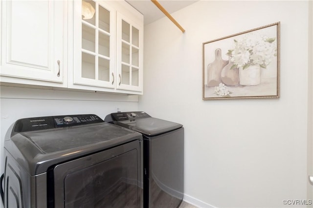 laundry area featuring separate washer and dryer and cabinets