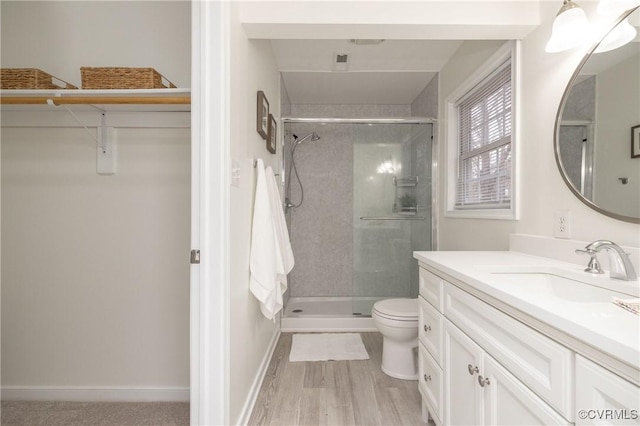 bathroom with vanity, hardwood / wood-style flooring, toilet, and walk in shower