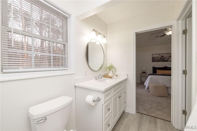 bathroom featuring vanity, hardwood / wood-style flooring, toilet, and ceiling fan