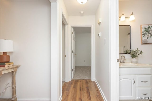 hall featuring sink and light wood-type flooring