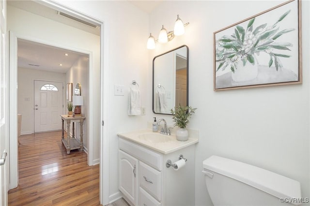 bathroom with hardwood / wood-style floors, vanity, and toilet