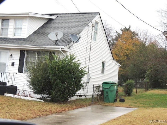 view of property exterior with a patio and a lawn