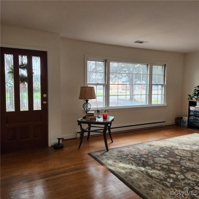 foyer entrance featuring a baseboard radiator and hardwood / wood-style flooring