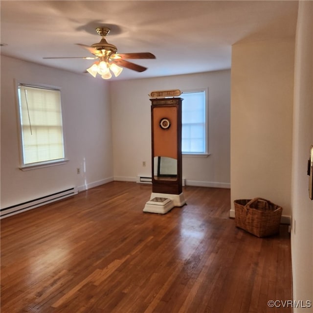 unfurnished room with dark hardwood / wood-style flooring, ceiling fan, and a baseboard heating unit