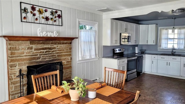 kitchen featuring a healthy amount of sunlight, visible vents, a sink, appliances with stainless steel finishes, and crown molding