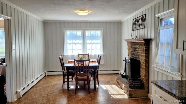 dining room featuring plenty of natural light, a baseboard heating unit, and ornamental molding