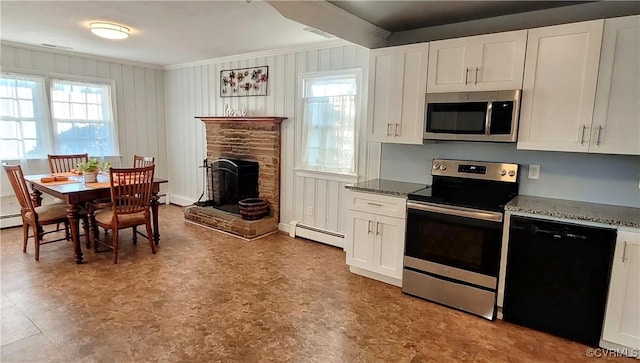 kitchen with dark stone countertops, baseboard heating, white cabinets, and appliances with stainless steel finishes