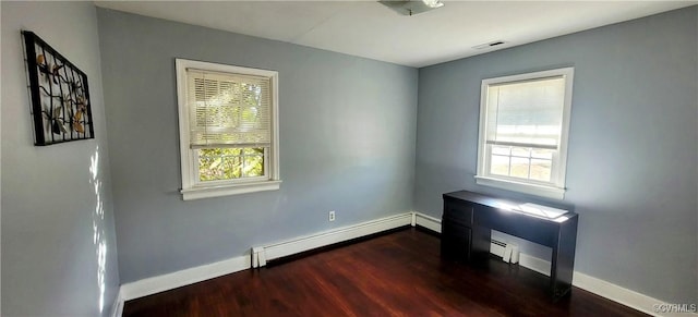 spare room featuring visible vents, a healthy amount of sunlight, dark wood-style flooring, and a baseboard radiator