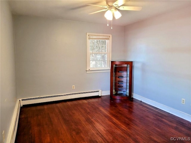 spare room featuring ceiling fan, a baseboard radiator, baseboards, and wood finished floors