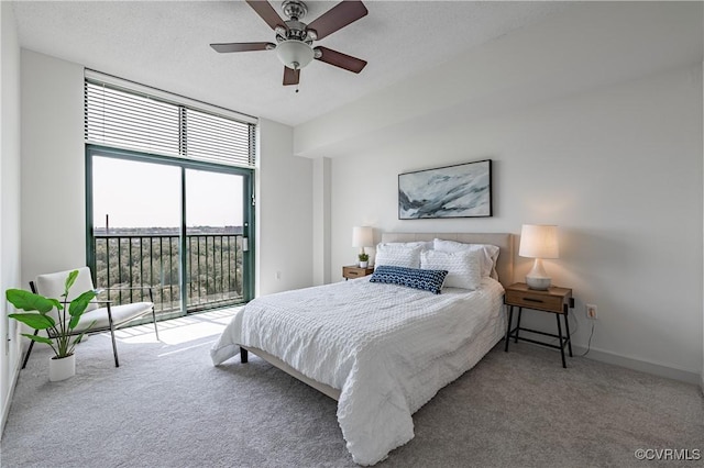 carpeted bedroom with access to outside, multiple windows, ceiling fan, and a wall of windows