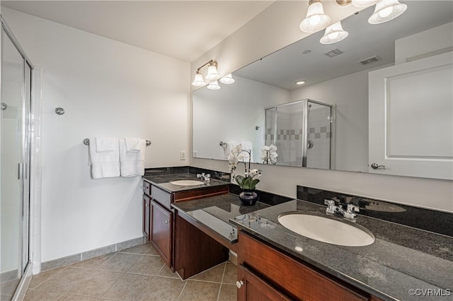 bathroom featuring tile patterned floors, vanity, an enclosed shower, and a notable chandelier