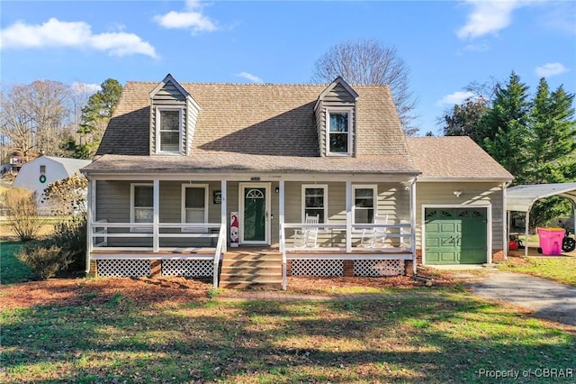 cape cod house featuring covered porch, a front yard, and a garage