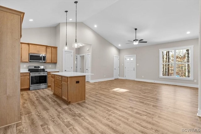 kitchen with a kitchen island, decorative light fixtures, ceiling fan, stainless steel appliances, and light hardwood / wood-style flooring