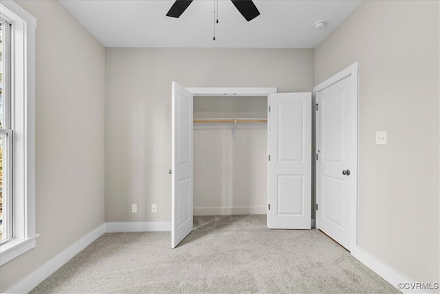 unfurnished bedroom featuring multiple windows, light colored carpet, and a closet