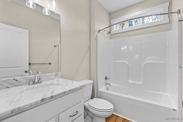 full bathroom with vanity, bathtub / shower combination, hardwood / wood-style floors, and toilet