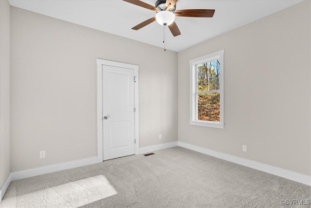 spare room with ceiling fan and carpet