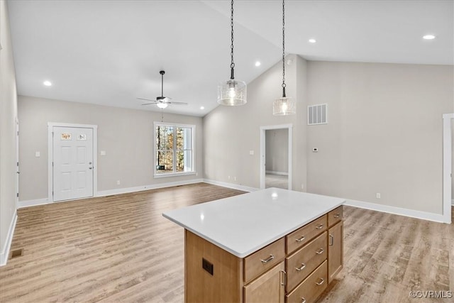 kitchen featuring pendant lighting, ceiling fan, a kitchen island, and light hardwood / wood-style flooring