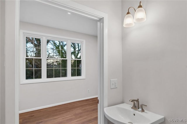 bathroom featuring wood-type flooring, a notable chandelier, and sink