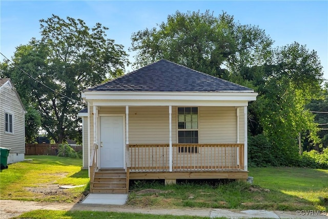 view of outbuilding with a porch and fence