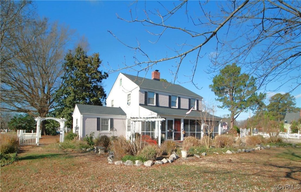 view of front facade with a sunroom and a front yard