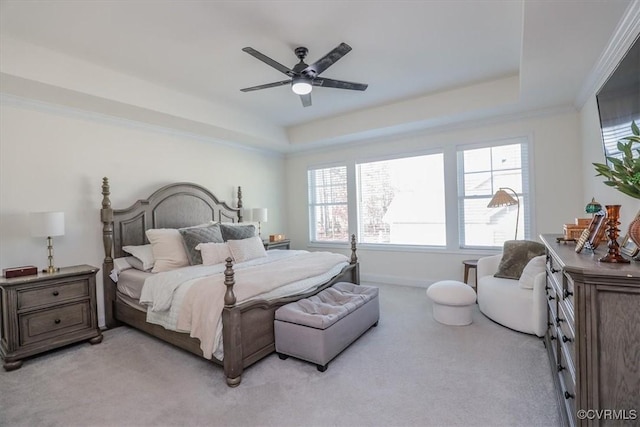 carpeted bedroom featuring a tray ceiling and ceiling fan