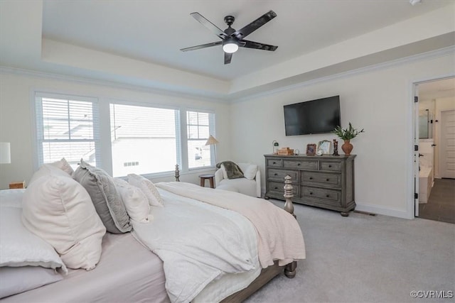 bedroom with ceiling fan, a tray ceiling, and light carpet