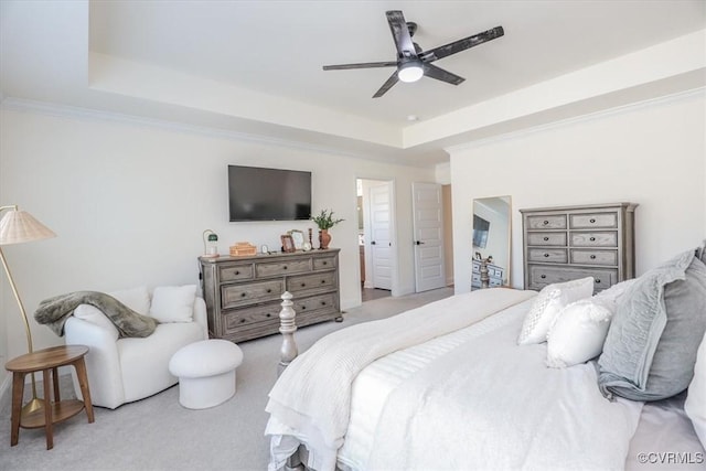 bedroom with crown molding, ceiling fan, a tray ceiling, and light colored carpet