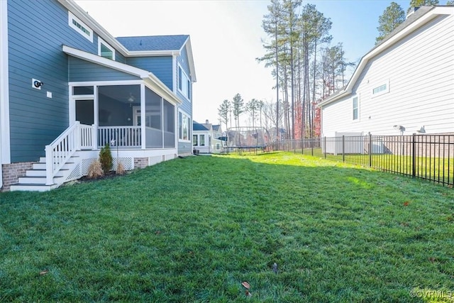 view of yard with a sunroom and a trampoline