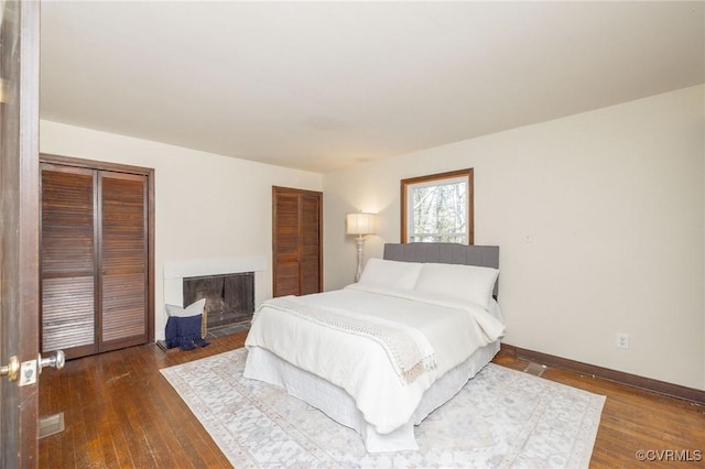 bedroom with dark hardwood / wood-style flooring and a closet