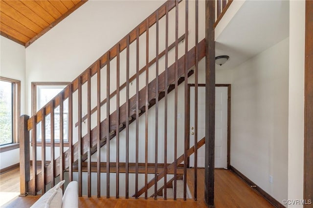 stairway with hardwood / wood-style floors, vaulted ceiling, and wood ceiling