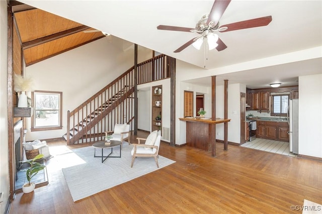 unfurnished living room with light hardwood / wood-style flooring, a wealth of natural light, wooden ceiling, and sink