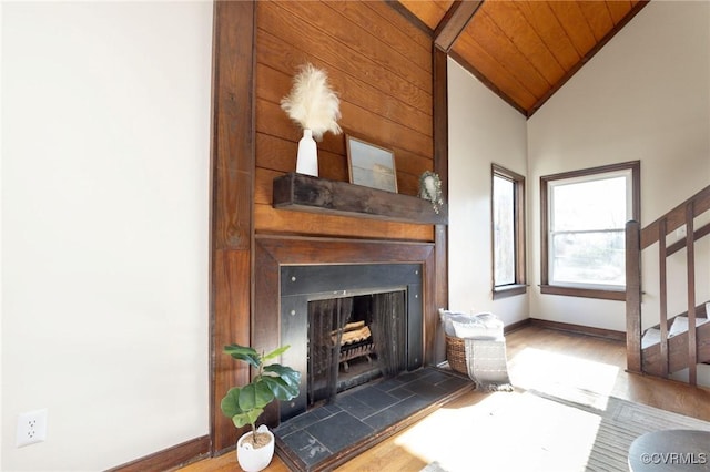 unfurnished living room featuring a tile fireplace, high vaulted ceiling, wood ceiling, and hardwood / wood-style flooring