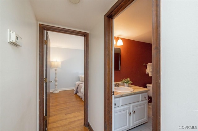 corridor featuring light wood-type flooring and sink