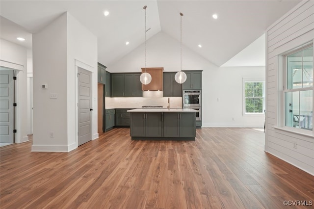2219 Silver St, Aylett, VA 23009 - kitchen with stainless steel double oven, light countertops, high vaulted ceiling, light wood-style flooring, and backsplash