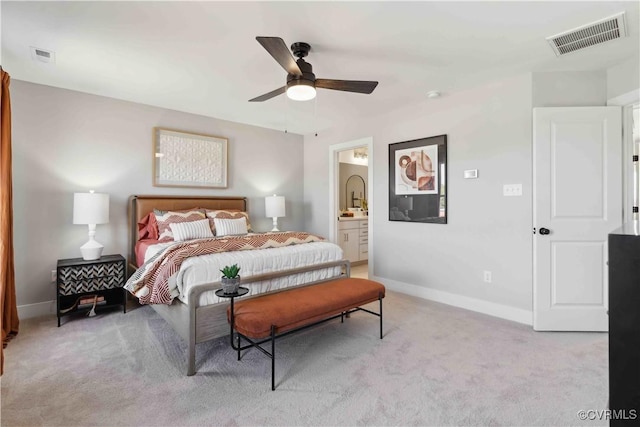 carpeted bedroom with ceiling fan, ensuite bath, visible vents, and baseboards