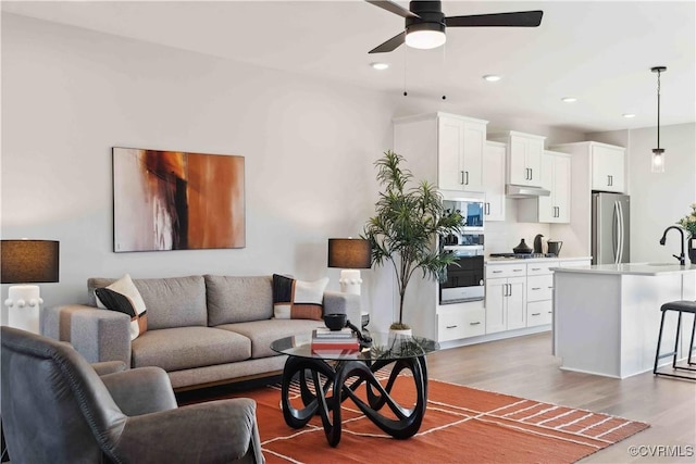 living room featuring a ceiling fan, wood finished floors, and recessed lighting