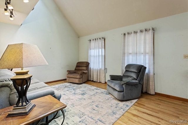 living room with wood-type flooring and vaulted ceiling