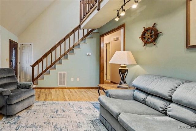 living room with hardwood / wood-style floors and high vaulted ceiling