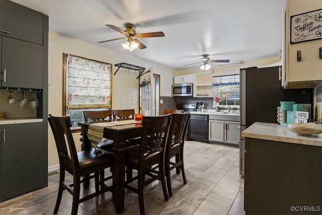 dining room with ceiling fan, light tile patterned flooring, and sink