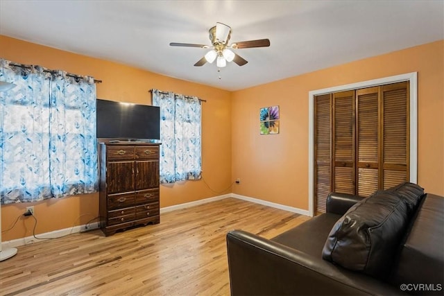 living room with ceiling fan and light hardwood / wood-style flooring