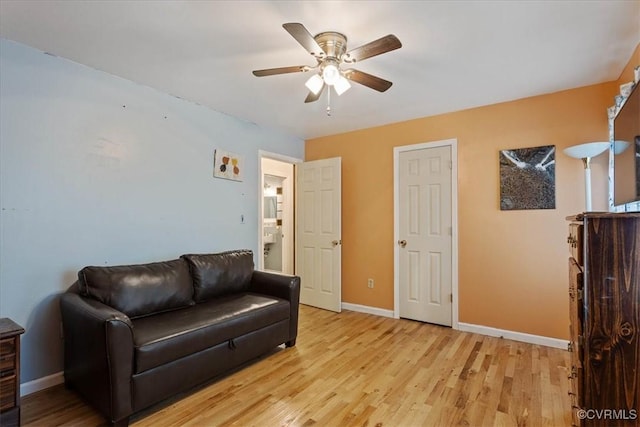 living room featuring ceiling fan and light hardwood / wood-style floors