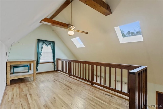 bonus room with ceiling fan, vaulted ceiling with skylight, and light hardwood / wood-style floors