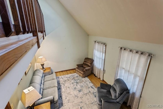 living room featuring lofted ceiling and light hardwood / wood-style flooring