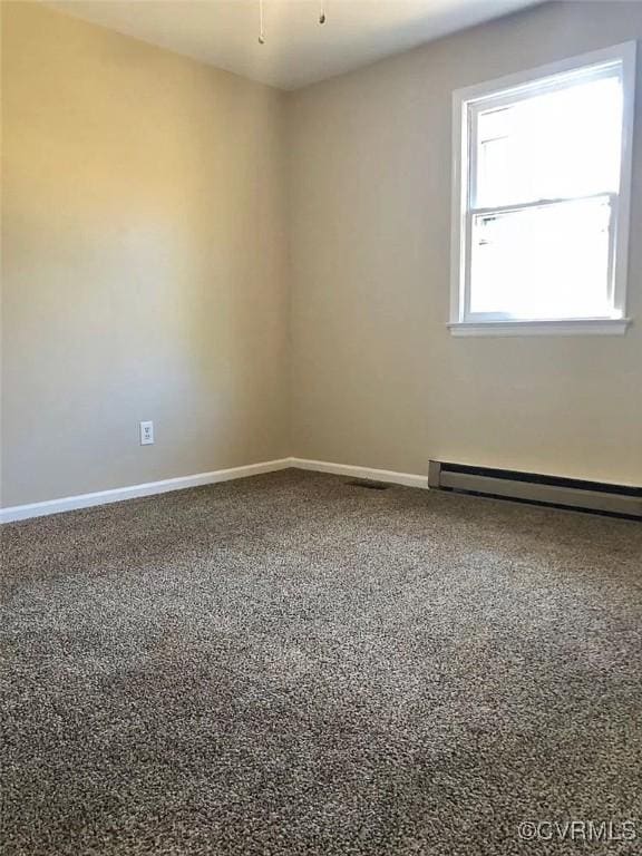 carpeted empty room with ceiling fan and a baseboard heating unit