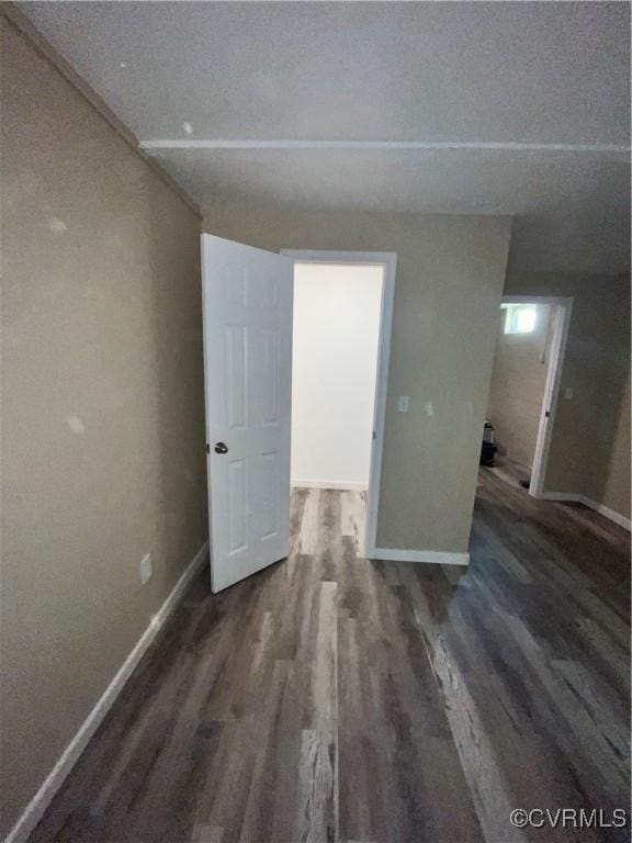 spare room with a textured ceiling and dark hardwood / wood-style floors