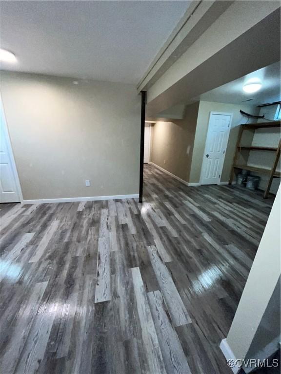 basement featuring a textured ceiling and dark hardwood / wood-style floors