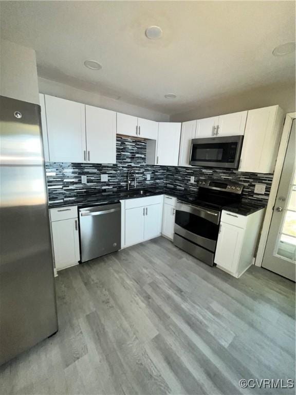 kitchen featuring light hardwood / wood-style floors, white cabinetry, and appliances with stainless steel finishes