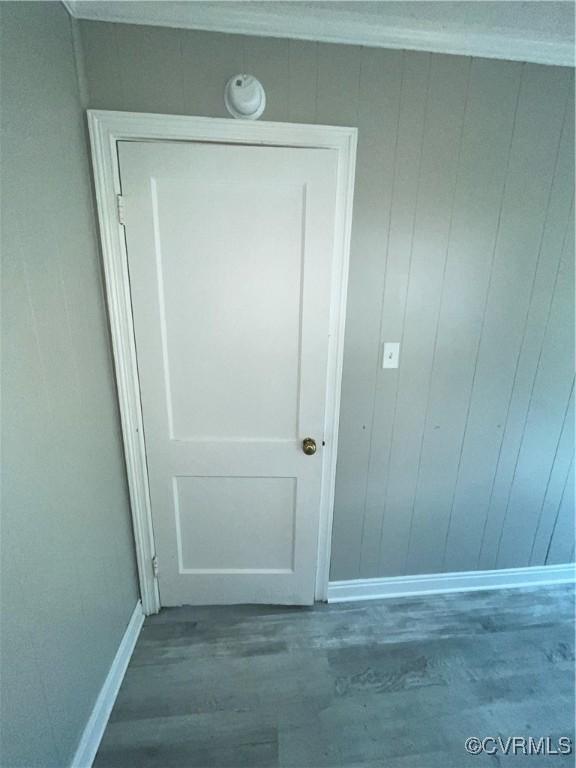 interior space with hardwood / wood-style flooring and wooden walls