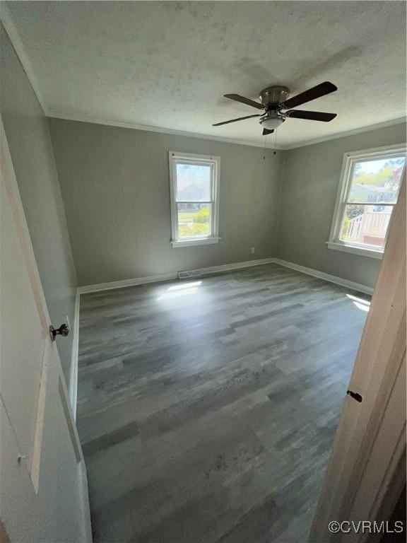 empty room with hardwood / wood-style flooring, ceiling fan, a healthy amount of sunlight, and a textured ceiling